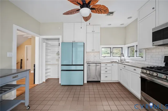 a kitchen with granite countertop white cabinets stainless steel appliances and a sink