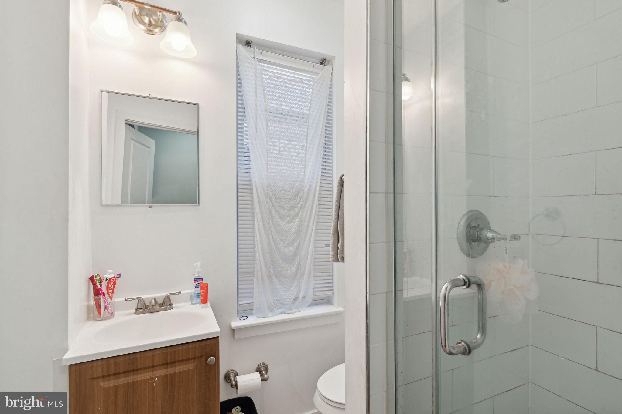1715 Monument Street Philadelphia, PA 19121 - Photo 18 of 30 a bathroom with a sink vanity mirror and toilet