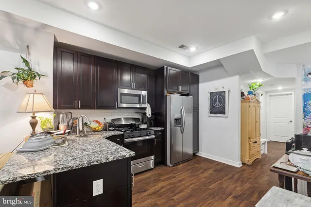 a kitchen with granite countertop stainless steel appliances a sink stove and refrigerator