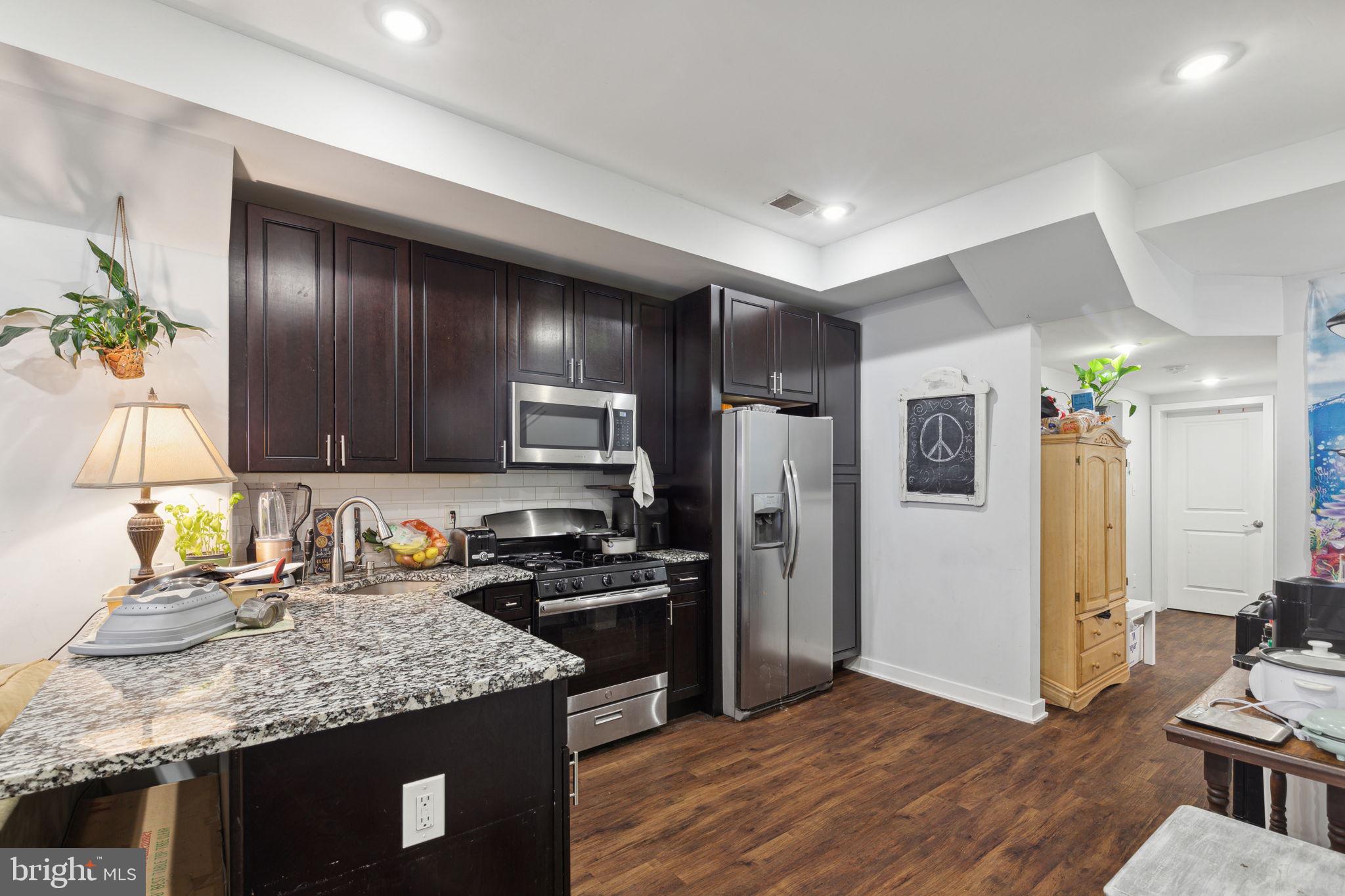 1715 Monument Street Philadelphia, PA 19121 - Photo 6 of 30 a kitchen with granite countertop stainless steel appliances a sink stove and refrigerator