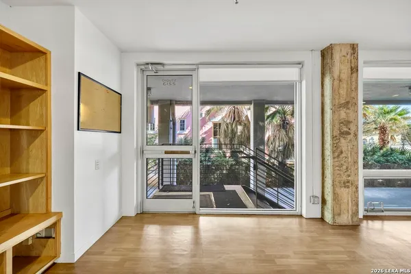 a view of a hallway with wooden floor and living room