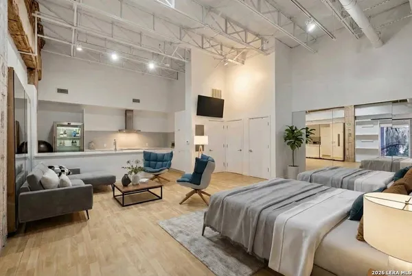 a spacious bedroom with a bed a couch and chandelier