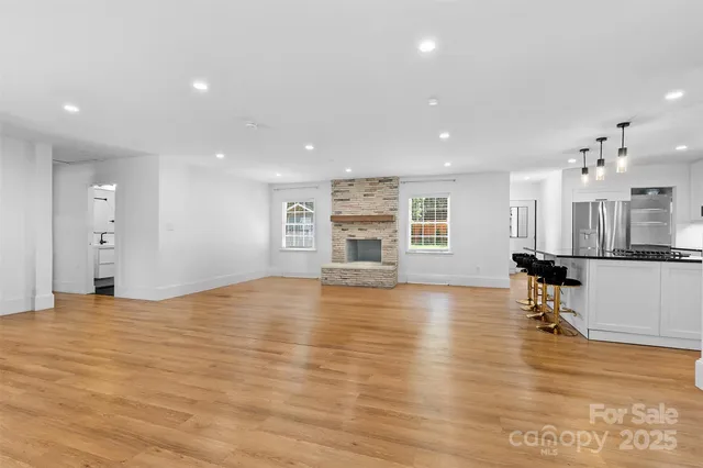 a view of empty room with wooden floor and fireplace