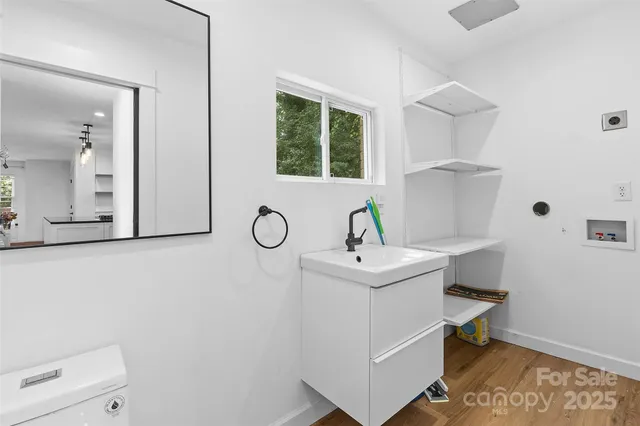 a bathroom with a sink a toilet and a window