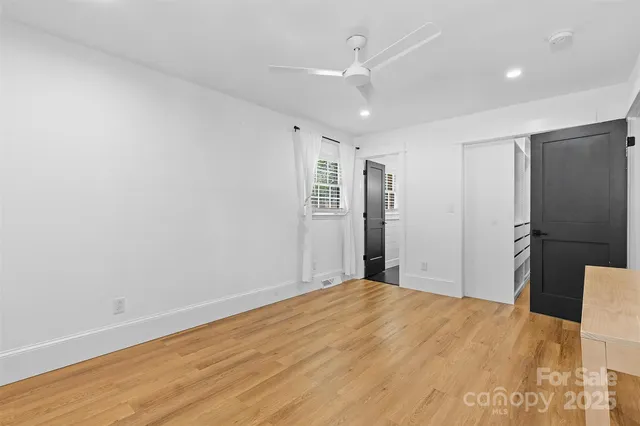 a big room with wooden floor and windows