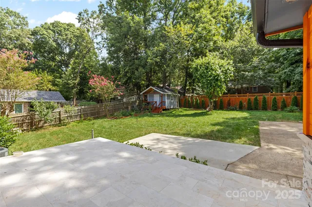a view of a house with a big yard and large trees