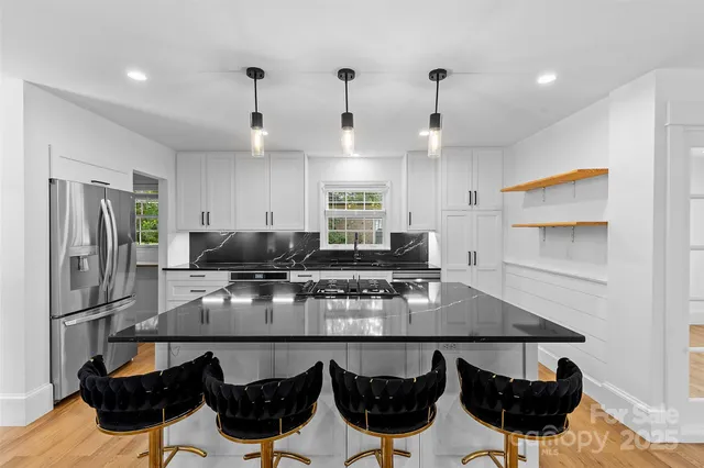 a kitchen with stainless steel appliances granite countertop a stove and a refrigerator