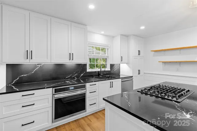 a kitchen with granite countertop a stove and a sink