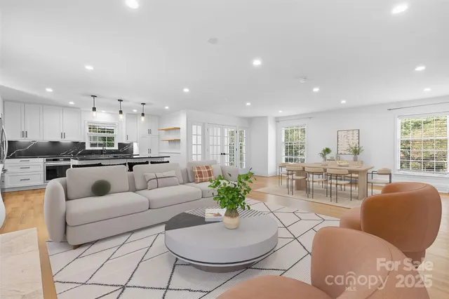 a living room with furniture white walls and white kitchen view