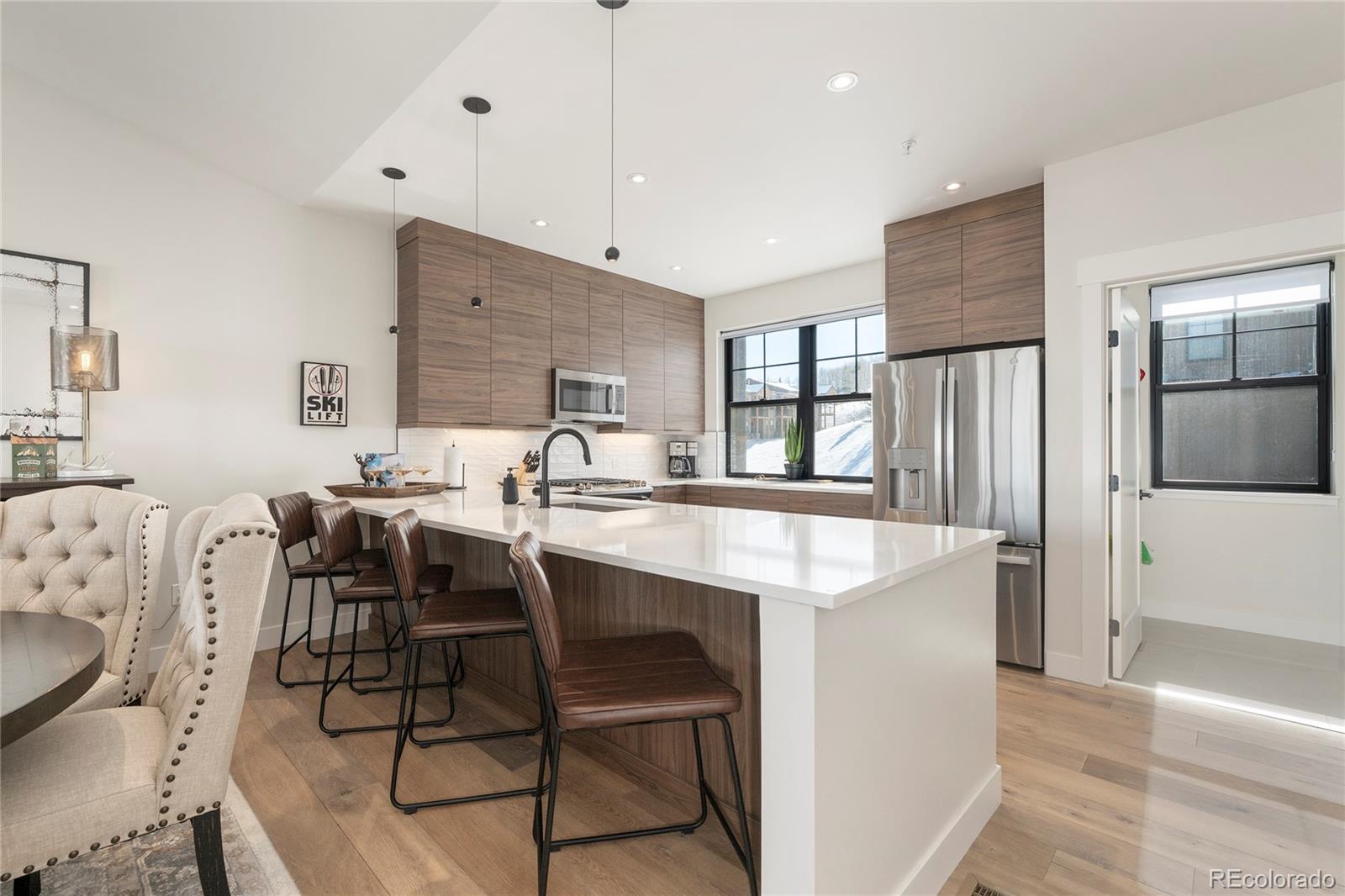 109 Saddle Mountain Camp Road Granby, CO 80446 - Photo 13 of 50 a kitchen with stainless steel appliances kitchen island a table chairs in it and wooden floors
