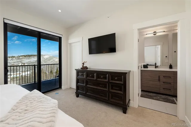 a bedroom with a bed a flat screen tv and guitar