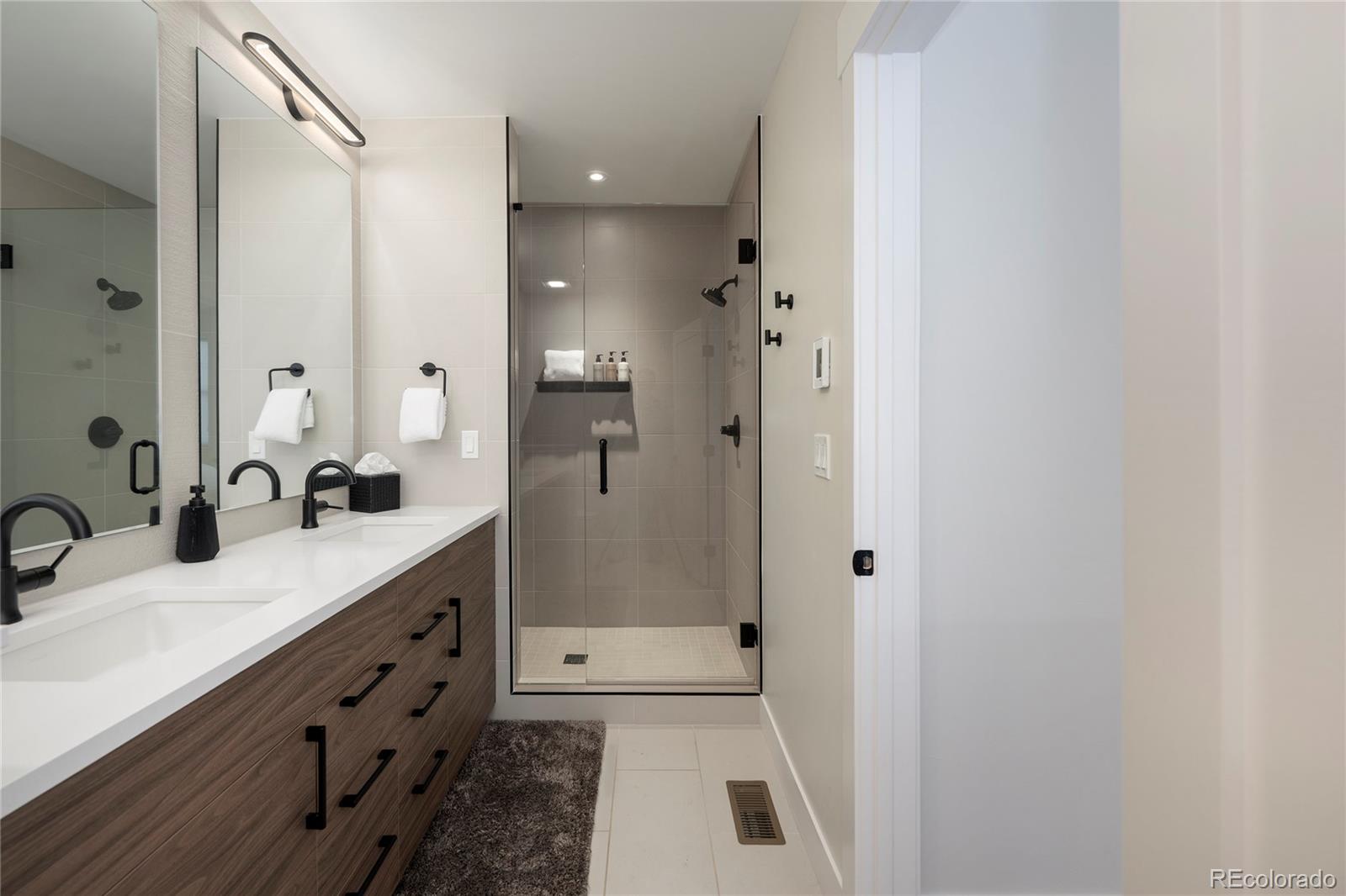109 Saddle Mountain Camp Road Granby, CO 80446 - Photo 33 of 50 a bathroom with a double vanity sink mirror double shower and a bathtub