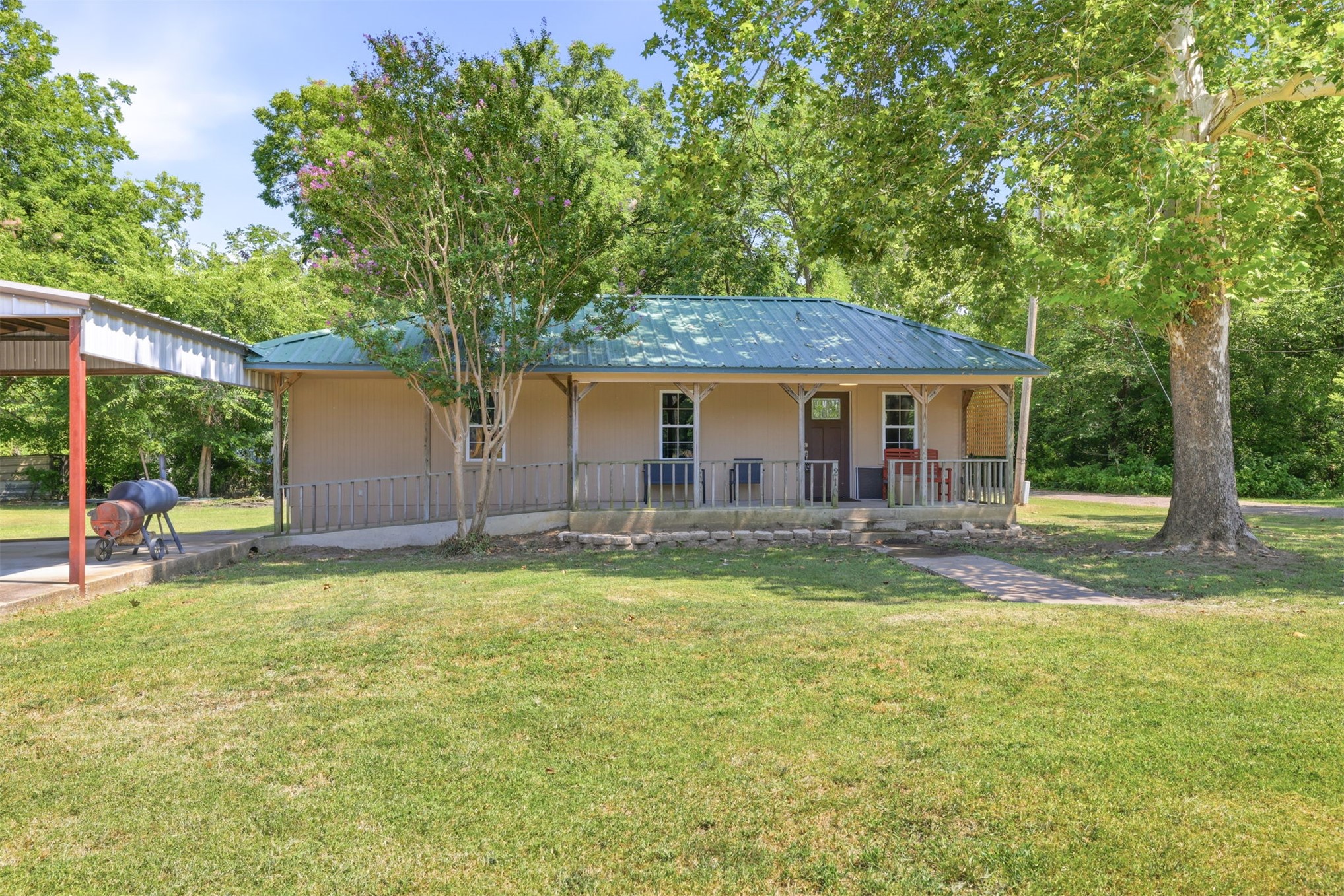 210 Main Caddo, OK 74729 - Photo 2 of 30 Single-story residence featuring a covered front porch, a green metal roof, and light-colored siding