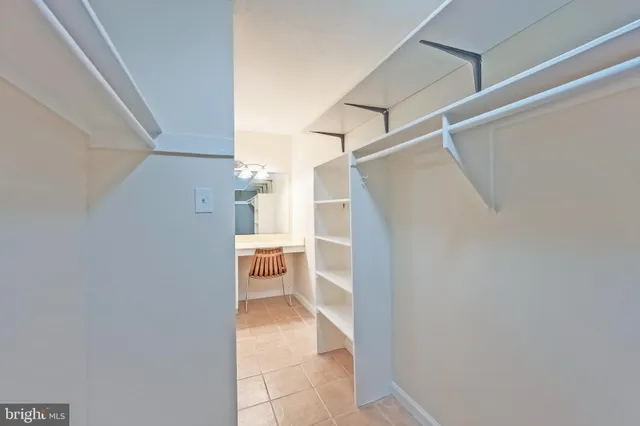 a view of a hallway with a white cabinet and a white door