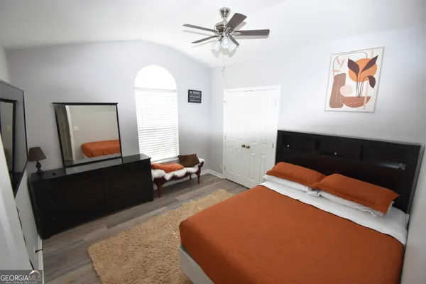 a bedroom with a bed and wooden floor