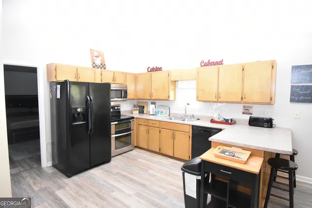 a kitchen with a refrigerator and a stove top oven