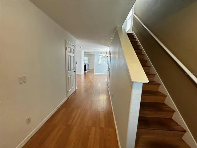 a view of a hallway with wooden floor and staircase