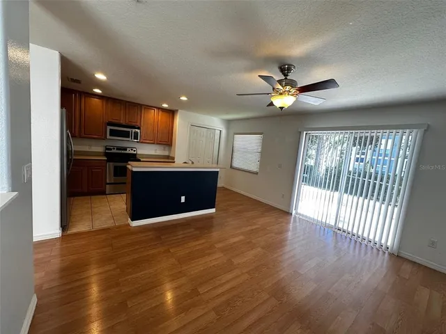 a view of kitchen with refrigerator stove and wooden floor