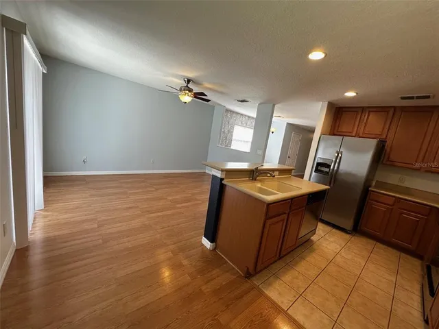 a kitchen with granite countertop a refrigerator a stove and a sink