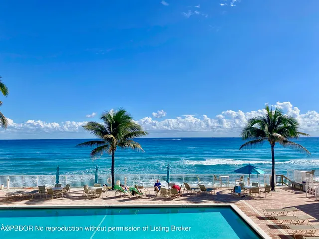 a view of a pool with a table and chairs