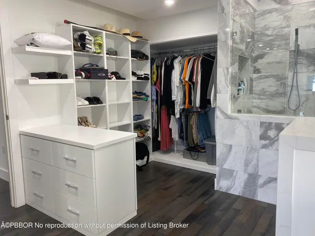 a view of walk in closet with clothes and shoes