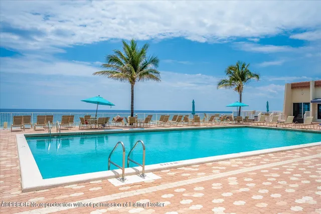 a view of a swimming pool with a yard and a fountain