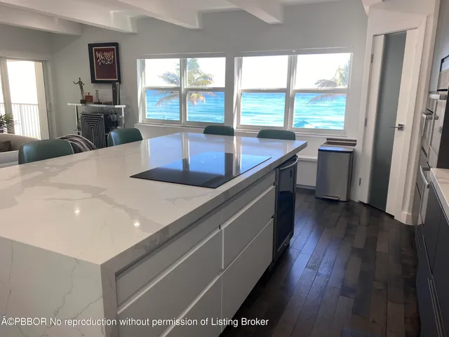 a kitchen with a sink a large window appliances and cabinets