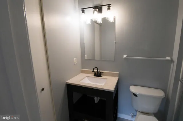 a bathroom with a sink a toilet and mirror