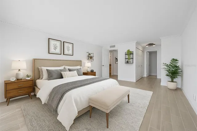 a spacious bedroom with a bed and a potted plant