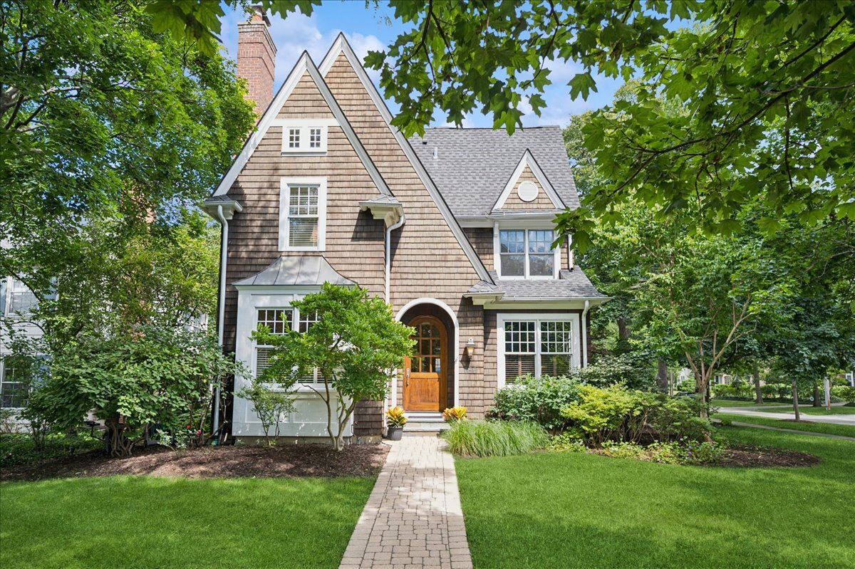 a front view of a house with a yard and potted plants