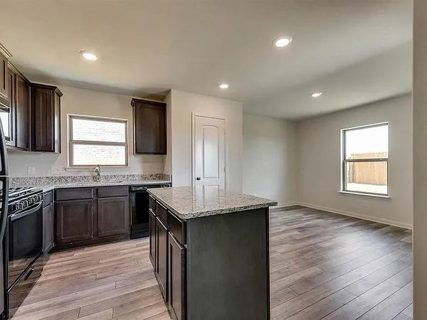 a kitchen with granite countertop cabinets stainless steel appliances a sink and a window