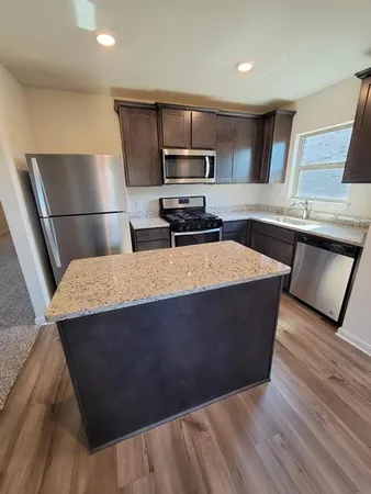 a kitchen with stainless steel appliances wooden cabinets a sink and a stove