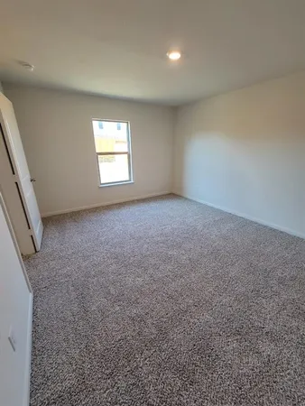 an empty room with a window and a kitchen