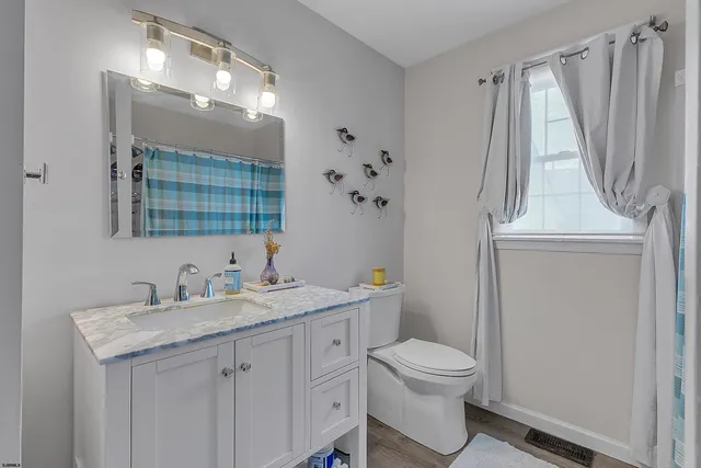 a bathroom with a sink a toilet and a mirror