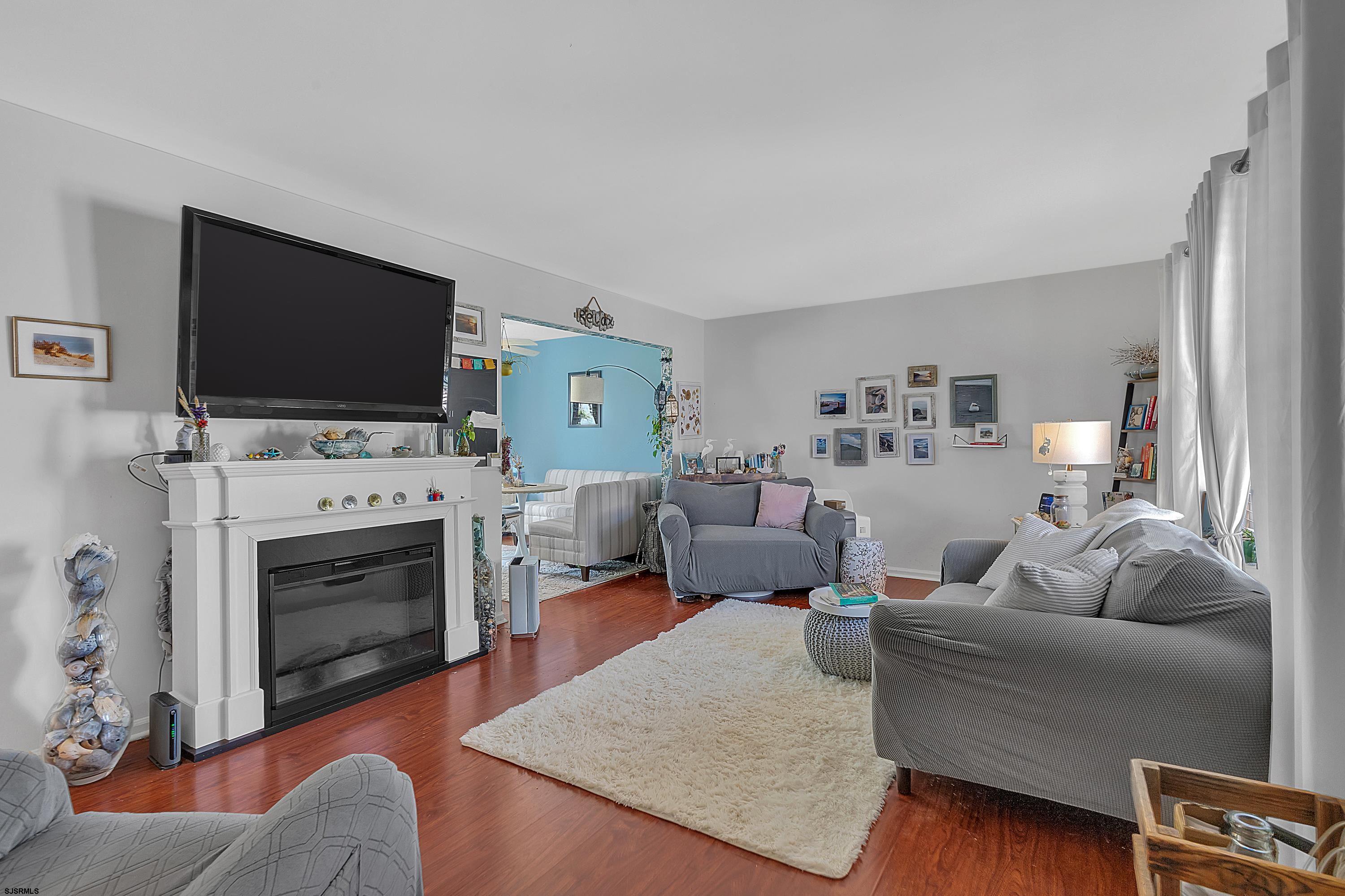 316 Gull Cove Brigantine, NJ 08203 - Photo 3 of 32 a living room with furniture a flat screen tv and a fireplace