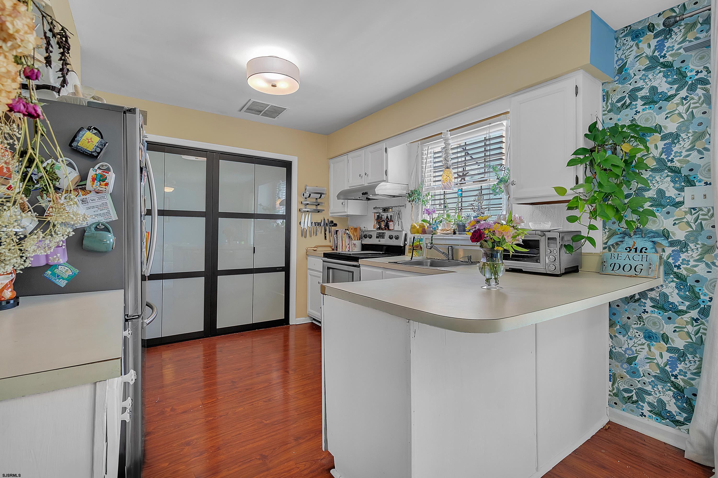 316 Gull Cove Brigantine, NJ 08203 - Photo 10 of 32 a kitchen with stainless steel appliances a sink a counter top space and living room view