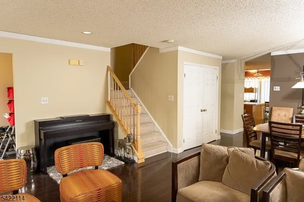 a kitchen with stainless steel appliances granite countertop a refrigerator a stove top oven a sink dishwasher and white cabinets with wooden floor