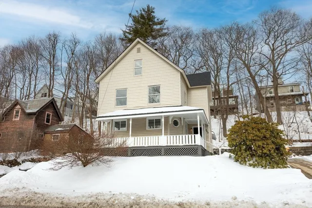 a front view of a house with a yard covered in snow