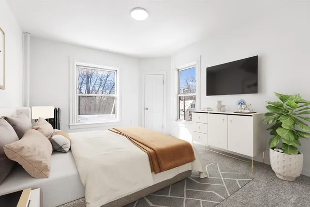 a bedroom with a bed and a flat screen tv