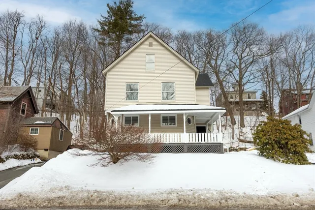 a front view of a house with a yard covered in snow