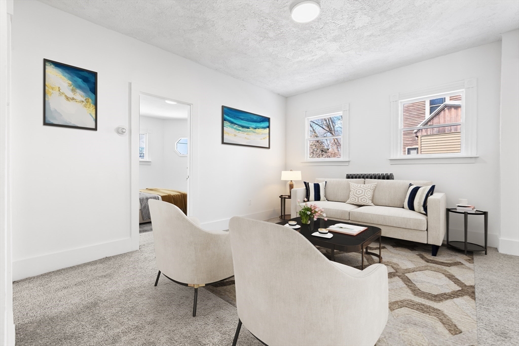 232 Pequoig Avenue, Unit 2 Athol, MA 01331 - Photo 8 of 17 a living room with furniture and a painting on the wall