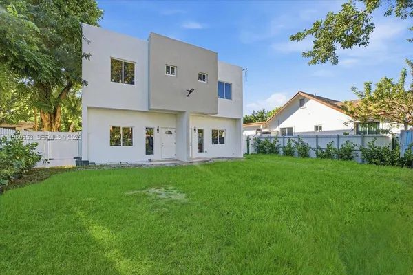 a view of a house with backyard and a tree