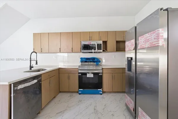 a kitchen with a refrigerator sink and stainless steel appliances