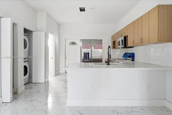 a view of a kitchen with stainless steel appliances granite countertop a refrigerator and a sink