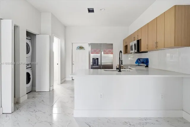 a view of a kitchen with stainless steel appliances granite countertop a refrigerator and a sink
