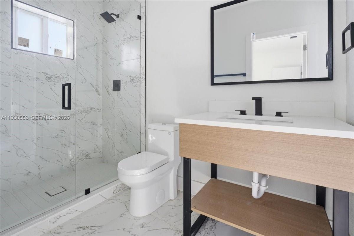 1126 Northwest 28th Street, Unit 1126 Miami, FL 33127 - Photo 6 of 26 a bathroom with a sink a toilet and shower