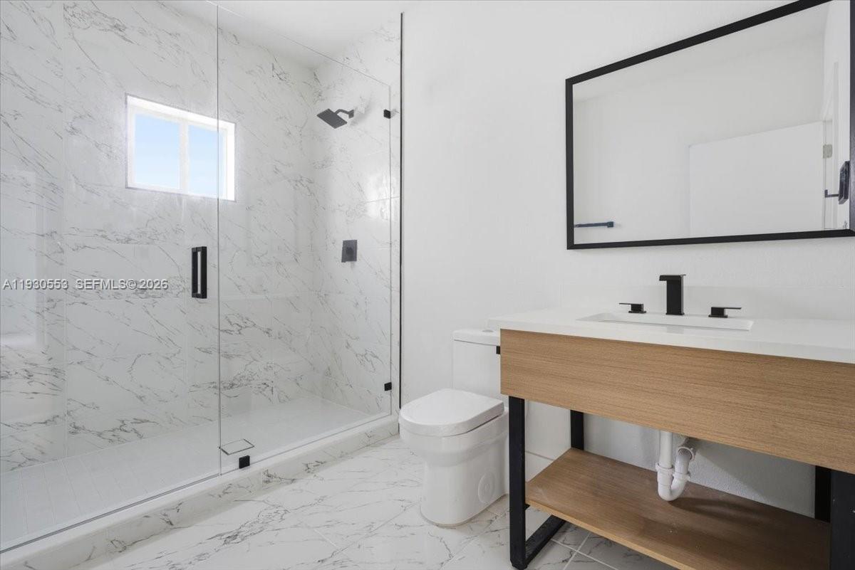 1126 Northwest 28th Street, Unit 1126 Miami, FL 33127 - Photo 10 of 26 a bathroom with a sink a toilet and shower