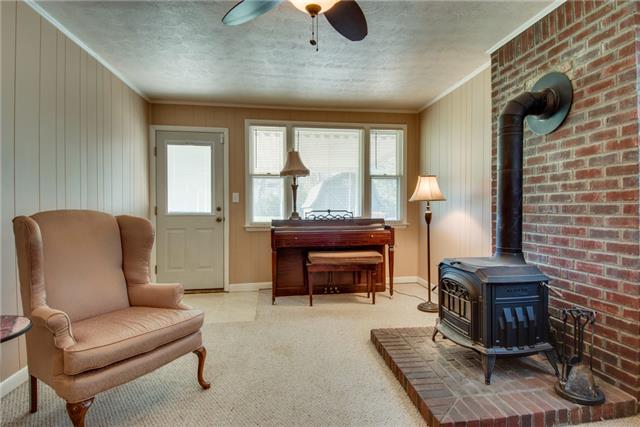 313 Gates Road Goodlettsville, TN 37072 - Photo 8 of 19 A wood burning stove keeps the den cozy and warm--this is a great place to enjoy the game or curl up with a book. The half-view door walks out to the backyard and large patio space.