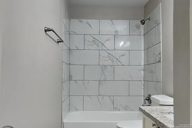 a bathroom with a granite countertop bathtub a shower and vanity