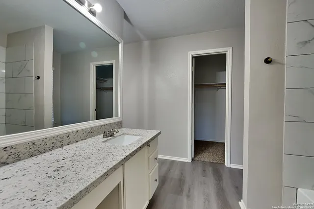 a bathroom with a granite countertop sink and mirror